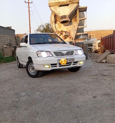 Ağ rəngli Kia Pride sedan. Avtomobilin ön hissəsində halojen tipli