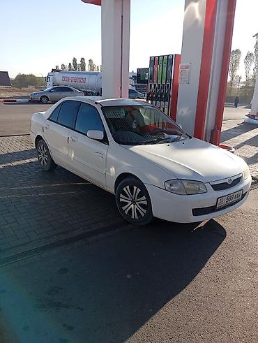e6 3: Mazda Familia седан, белый цвет. Компактный городской автомобиль с — 1