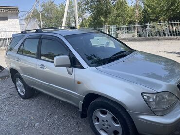 Toyota: Автомобиль Lexus Rx 300 серебристого цвета с рейлингами на крыше. Это