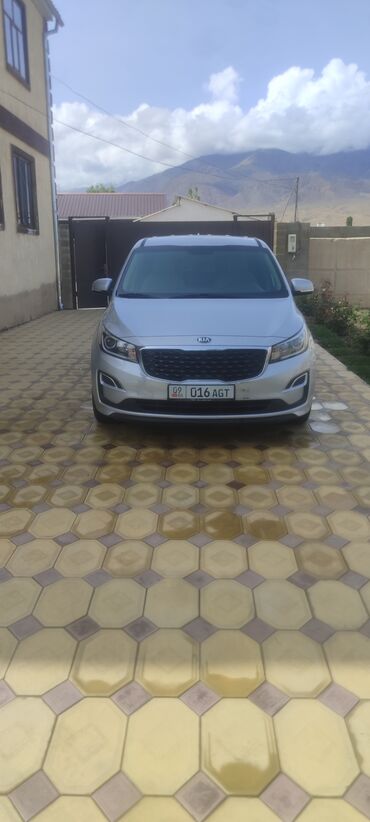 дом на колосах: Kia Carnival / Grand Sedona (емблемы Kia на кузове), серебристый