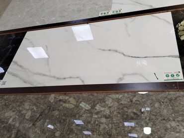 Ağ rəngdə, mərmər naxışlı keramik plitə. Üzərindəki boz damarlar təbii