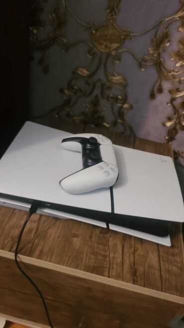 ps5 oyunlar: Ağ rəngdə olan PlayStation 5 oyun konsolu və DualSense oyun paneli