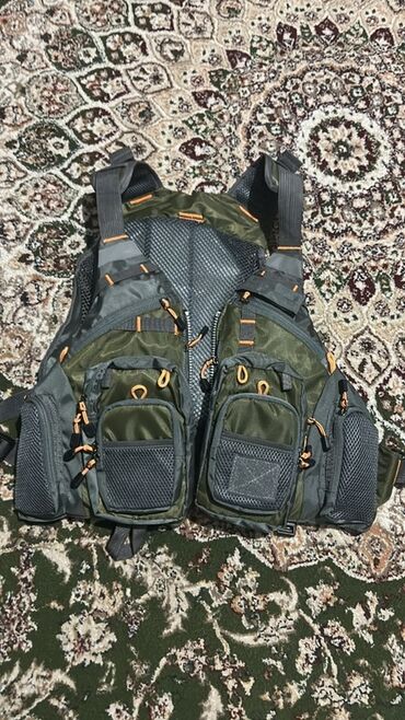 жилетку джинсовую: Рыболовный жилет с многочисленными карманами и отделениями. Изготовлен