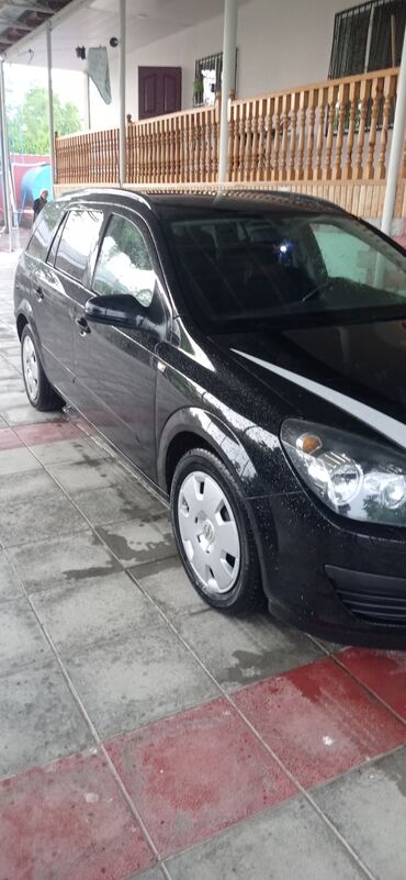 Opel: Qara rəngdə olan Opel Astra universal avtomobili. Avtomobilin ön — 4