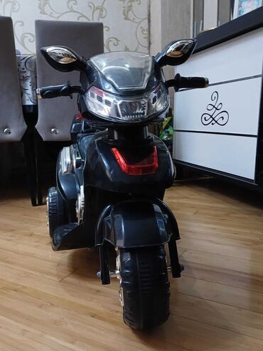 uşağ maşnı: Qara rəngdə olan uşaq elektrik motosikleti. Ön tərəfində işıqlar və