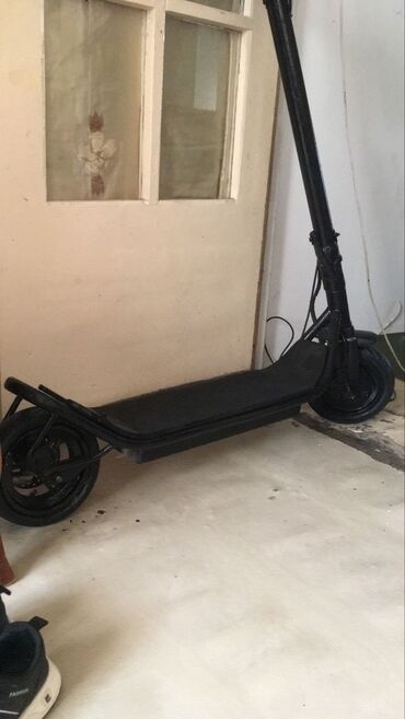 самокат электрический: Fırlanan qatlanan mexanizmə malik qara rəngli elektrik skuter. Sağ