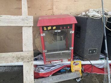 Kənd təssərüfatı avadanlığı: Şəffaf şüşə divarları və qırmızı metal korpusu olan bu popkorn