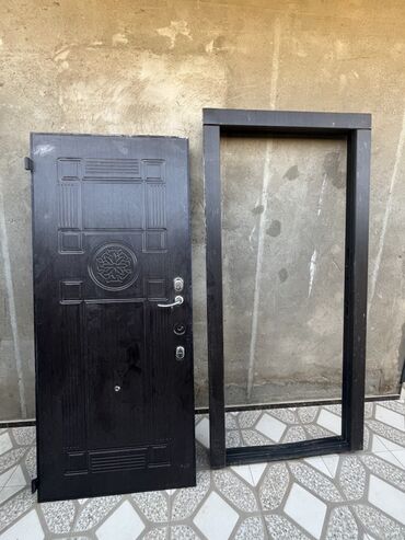 Bunker qapıları: Tünd rəngli metal qapı dəsti, dekorativ elementlər və möhkəm çərçivə