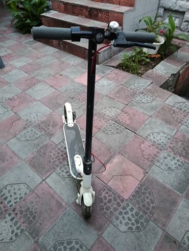 elektrik samokat: Ağ rəngdə elektrik skuter. Qara sükan və idarəetmə paneli ilə təchiz