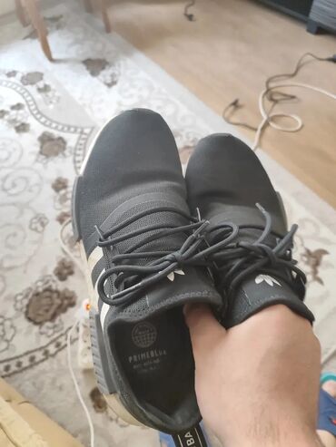 Krasofkalar və idman ayaqqabıları: Qara rəngli, zolaqlı Adidas idman ayaqqabıları. Bağlı və rahat dizaynı