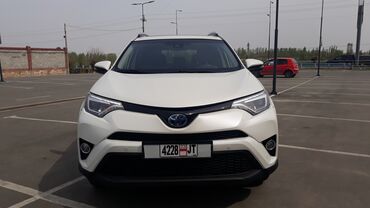 шины 2356516c: Белый кроссовер Toyota RAV4 с заметным логотипом Toyota на передней и