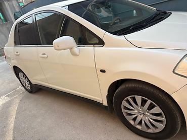 nisan note: Ağ rəngli Nissan Tiida sedan. Avtomobilin salonu açıq bej tonlarda — 9
