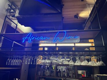 Ленточные лампы: Bu, "African Wine" sözləri yazılmış mavi rəngli neon işıqlandırmadır