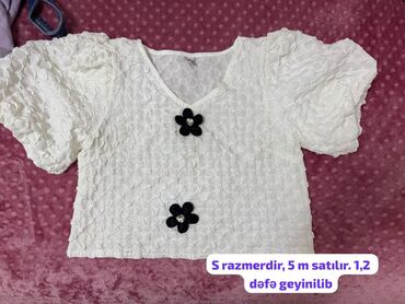 Köynək və bluzalar: Ağ rəngdə, qabarıq fakturalı, qısaqol bluz. Sinə hissəsində iki ədəd