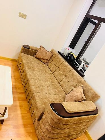 Divanlar: Qəhvəyi tonlarda, yumşaq toxumalı parça ilə üzlənmiş geniş divan. - — 1