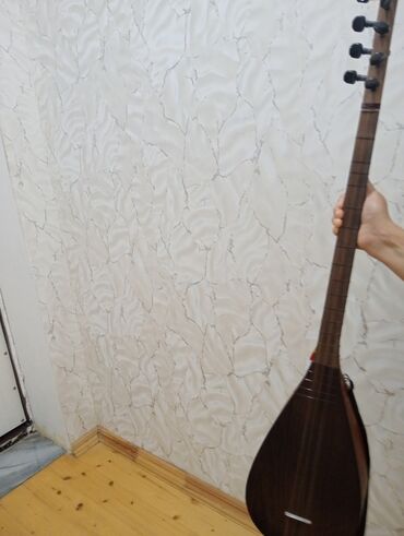 Гитары: Tünd qəhvəyi rəngdə, armud formalı gövdəyə malik simli musiqi aləti