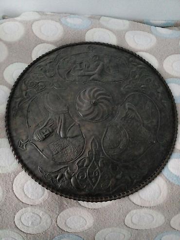 divarda dekor: Dairəvi formada, metal materialdan hazırlanmış bəzək qalxanı. Üzərində — 4