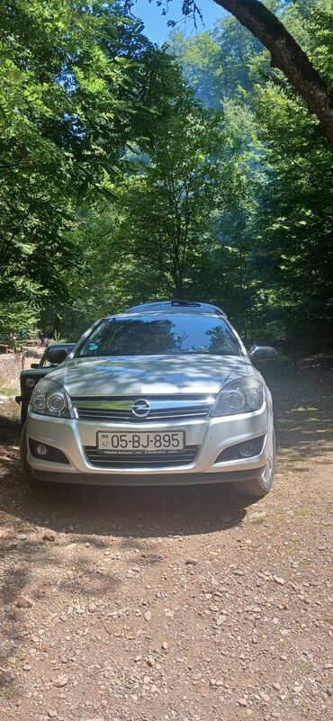 salon oturacaqları: Gümüşü rəngli Opel Astra hetçbek avtomobili. Dinamik cizgiləri və
