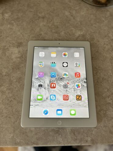 Apple iPad: Gümüşü rəngdə olan Apple iPad planşeti. Planşet, müxtəlif proqramları
