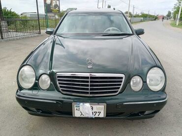mersedes maşını: Tünd yaşıl rəngdə olan Mercedes-Benz E-Class sedanı. Avtomobil rahat