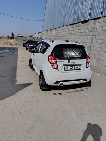 мини электромобиль: Белый хэтчбек Chevrolet Spark, представленный на снимках, имеет