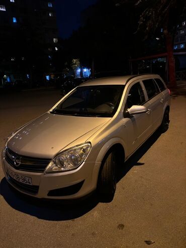 Ön görünüşdən görünən gümüşü rəngli Opel Astra avtomobili. Avtomobilin
