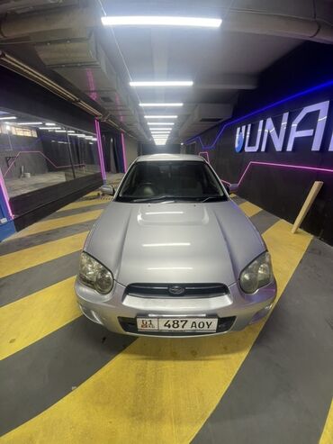 эмблема авто: Серебристый автомобиль Subaru Impreza с характерным дизайном передней