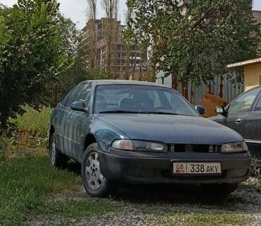 не рабочий на запчасти: Седан Mazda 626 темно-зеленого цвета с четырьмя дверями. Автомобиль