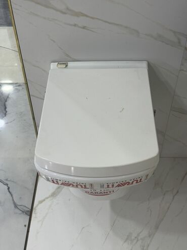 Hamam üçün kranlar: Ağ rəngdə, kvadrat formalı, qapaqlı universal unitaz. Bu unitaz hamam