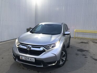 Honda: Honda CR-V серебристого цвета. Этот компактный кроссовер отлично