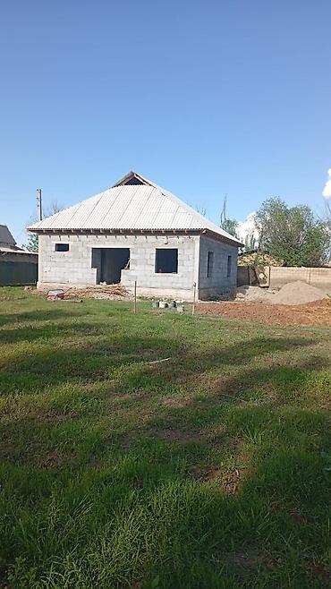 Дом из блоков с двускатной крышей на участке с ровным газоном