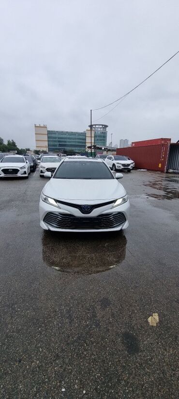 камри 55 европеец гибрид: Белый седан Toyota Camry Hybrid, оснащенный светодиодными фарами и