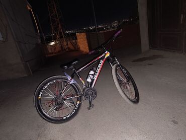 Velocruz markalı, qara rəngli dağ velosipedi. Qırmızı və sarı rəngli