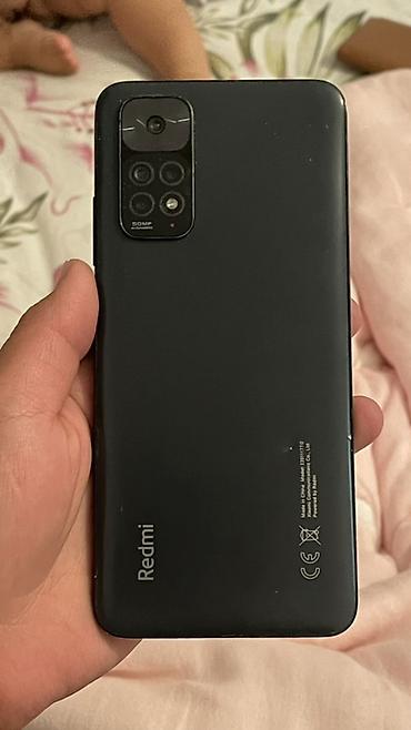 nothing наушники: Смартфон Redmi в чёрном цвете. На корпусе указан модуль камеры 50 MP — 2