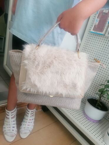 Torbe: Ženska torba sa preklopom od veštačkog krzna u bež boji. Torba ima dve — 3