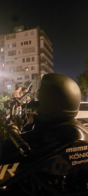 Motonəqliyyatın icarəsi: Fərqli kəllə dizaynlı, qara rəngli motosiklet dəbilqəsi. Bu dəbilqə