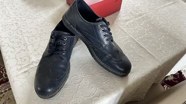 Ayaqqabılar: Qara rəngdə dəri kişi ayaqqabıları. Dəbli dizaynı ilə fərqlənən bu