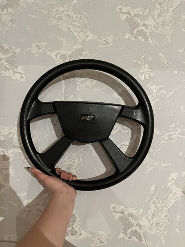 Radiatorlar: Avtomobil sükanı, qara rəngdə və dörd qolu var, mərkəzində "Chevrolet"