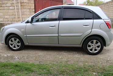 Kia: Kia Rio hatchback – gümüşü rəngdə, 5 qapılı şəhər avtomobili. Xarici — 3