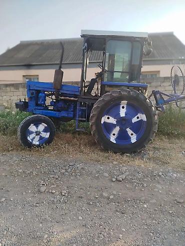 Mavi rəngli təkərli traktor - Kabinəli, geniş şüşəli görünüş: ön-yan
