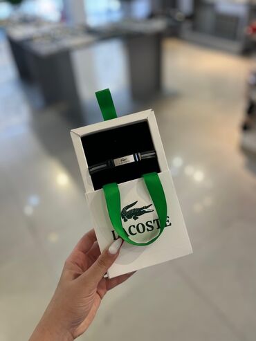 Lacoste brendinə məxsus qolbaq. Qara rəngli, üstündə ağ zolaqlar və