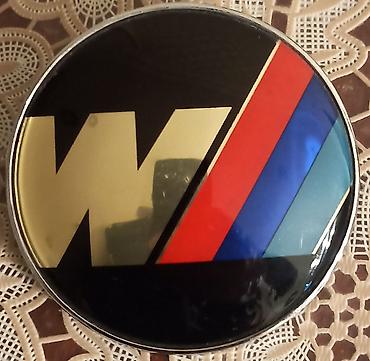 nissan march: Avtomobil üçün dekorativ emblem – dairəvi forma, parlaq qara fon — 1