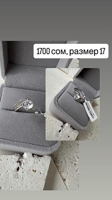 Ювелирные изделия: Кольцо с центральным круглым камнем и изящной волнообразной оправой — 1