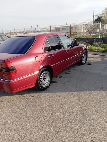 Mercedes-Benz: Qırmızı rəngdə olan Mercedes-Benz avtomobili. Sedan kuzovuna malikdir