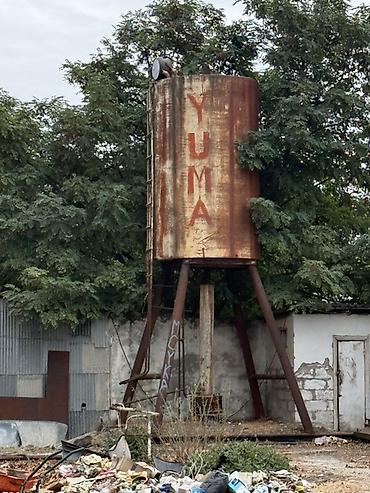 Metall su anbarı – “YUMA” yazılı, silindrik formalı, hündür dayaqlar