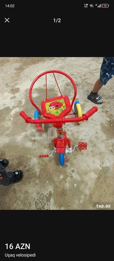 Elektrik velosipedlər: Uşaqlar üçün parlaq qırmızı rəngdə, üçtəkərli velosiped. Velosipedin