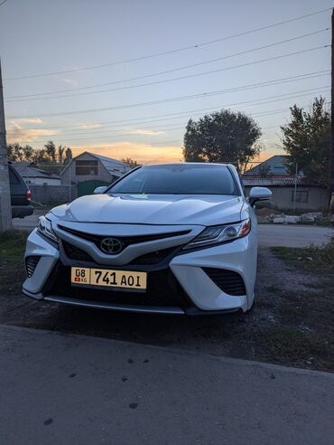 щетка стеклоочистителя: Белый седан Toyota Camry. Автомобиль с элегантным дизайном передней