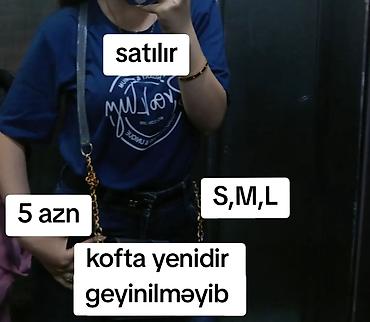 Mavi rəngdə qısaqoll qadın T‑şortu. Önündə ağ yazılı çap dizaynı var
