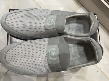 qaçış üçün qadın krosovkaları: Açıq boz rəngli, dəlikli üst hissəyə malik kişi slip-on kros qaçış