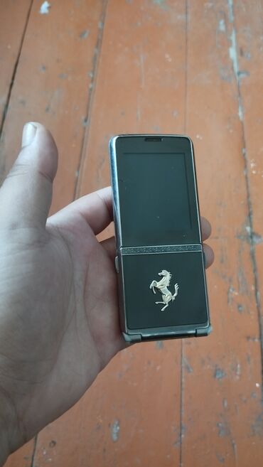 телефон fly iq4490 era nano 4: Ferrari loqosu ilə bəzədilmiş qapaqlı mobil telefon. Telefonun üst